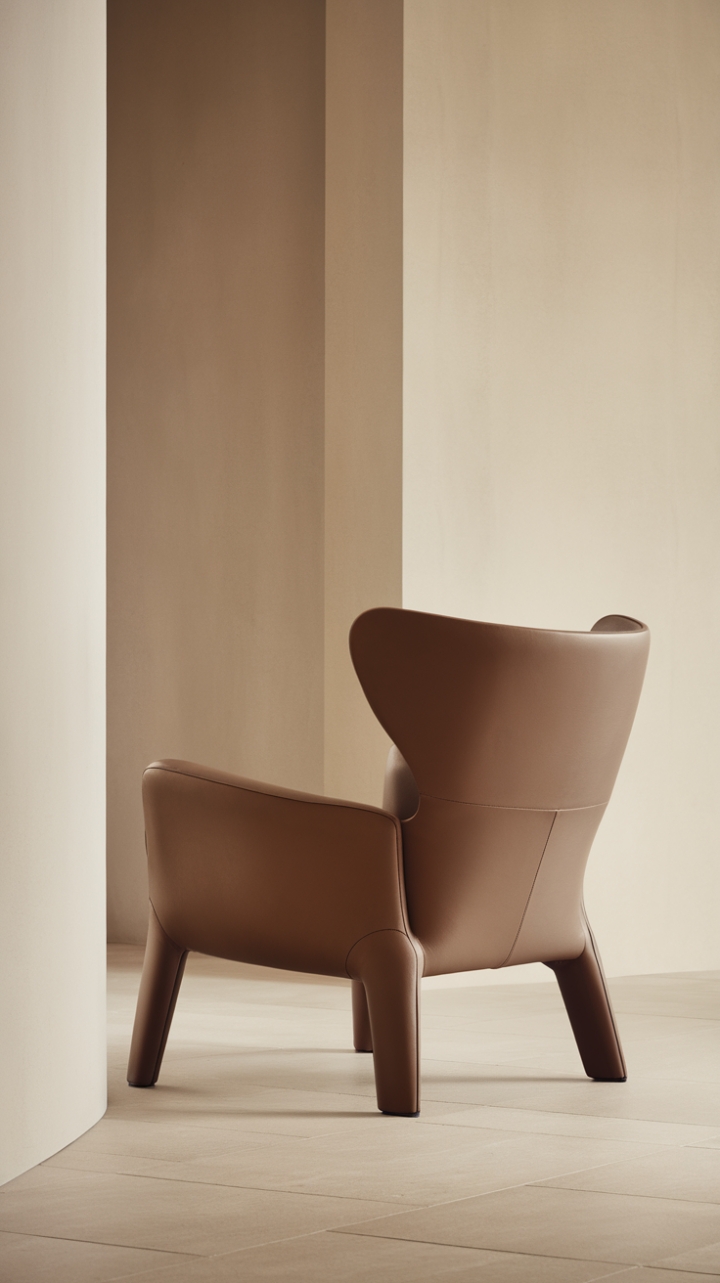 Sculptural curves meet minimalist chic in this haven of calm. A single, statement armchair commands attention against a backdrop of neutral tones, promising moments of quiet contemplation and understated elegance. The gentle curve of the backrest invites you to sink in and unwind.