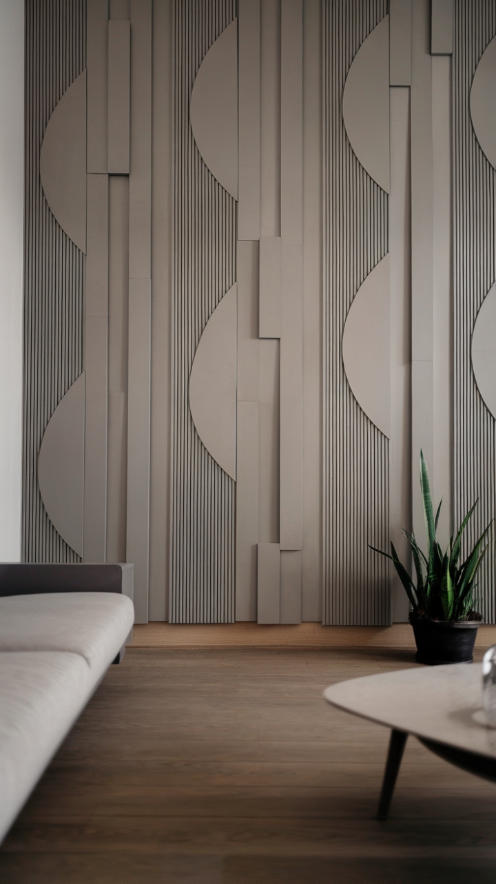 Sculptural gray wave panels clad the walls of this minimalist haven, their subtle texture a captivating backdrop to the clean lines of the furniture and warm wood flooring. A sanctuary of calm, defined by understated elegance.
