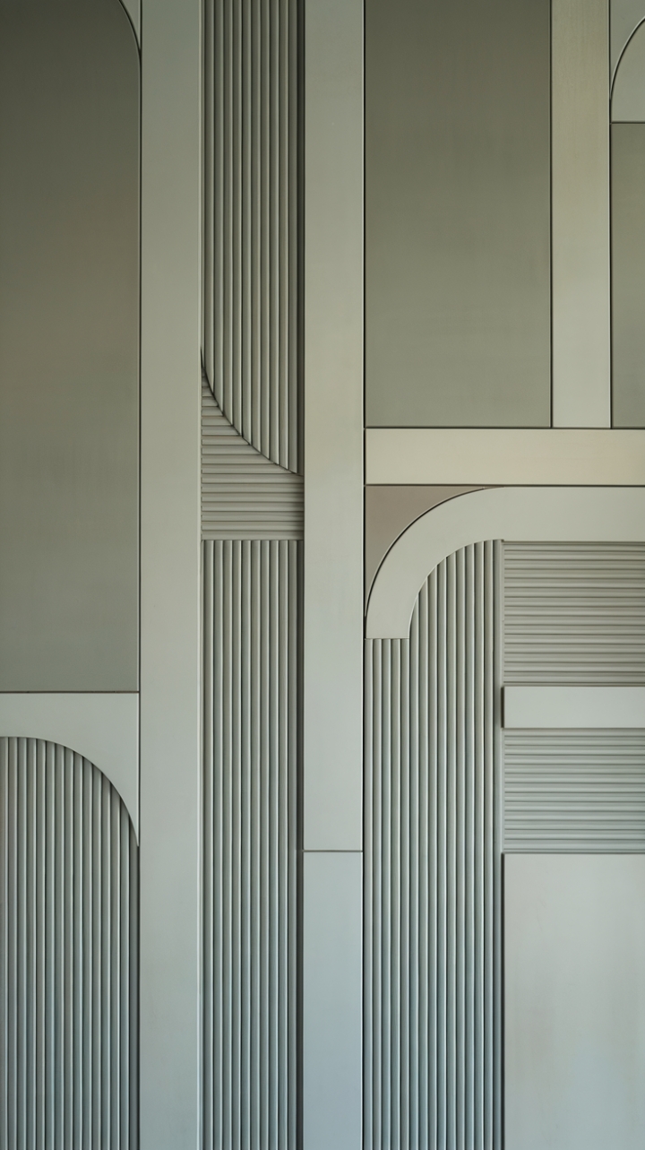 Experience the artistry of modern design with this stunning room. Subtle geometric patterns in shades of grey and white play across textured wall panels, lending a refined and quietly dramatic atmosphere to any contemporary interior.